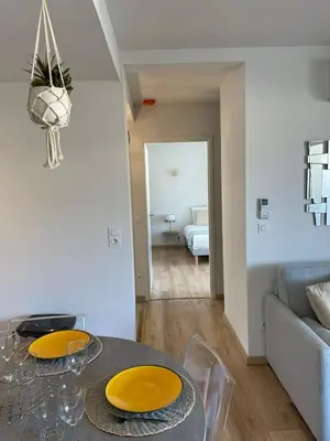 a living room with a table with yellow plates on it at T2 neuf port de Bonifacio avec parking privé in Bonifacio