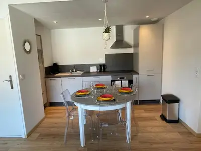 a kitchen with a table and chairs in a room at T2 neuf port de Bonifacio avec parking privé in Bonifacio