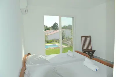 a bedroom with a white bed and a window at CASA VIGNA - villa T4 piscine privée in Sainte-Lucie de Porto-Vecchio
