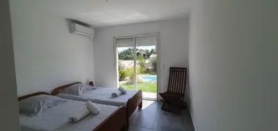 two beds in a room with a window at CASA VIGNA - villa T4 piscine privée in Sainte-Lucie de Porto-Vecchio