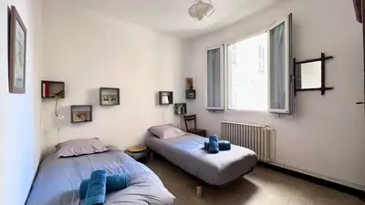 a bedroom with two beds and a window at Casamea - Spacieux, Famille, Hyper-centre in Ajaccio