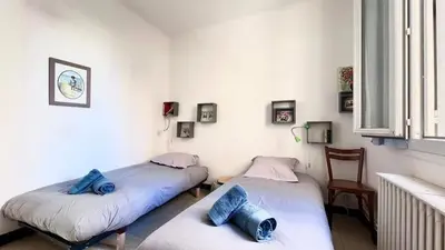 two twin beds in a room with a window at Casamea - Spacieux, Famille, Hyper-centre in Ajaccio