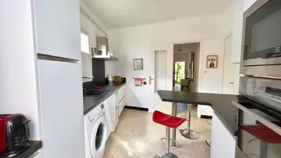 a kitchen with a counter and a red stool in it at Casamea - Spacieux, Famille, Hyper-centre in Ajaccio