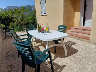 a white table with chairs and drinks on a patio at Maison à 15 minutes de Propriano in Santa-Maria-Figaniella