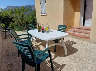 a white table with chairs and drinks on a patio at Maison à 15 minutes de Propriano in Santa-Maria-Figaniella