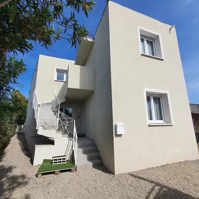 a white house with a staircase on the side of it at appartement Oliviaaxelle in Venzolasca