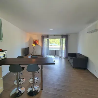 a living room with a large wooden table and chairs at appartement Oliviaaxelle in Venzolasca