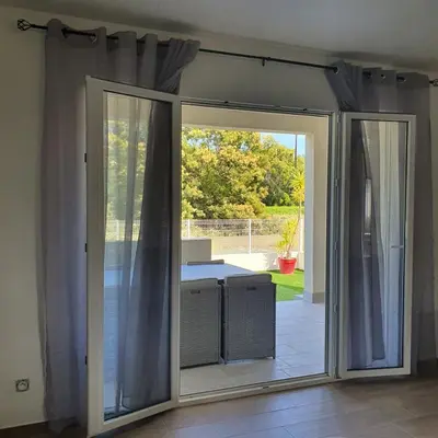 an open sliding glass door in a room with a patio at appartement Oliviaaxelle in Venzolasca