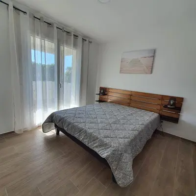 a bedroom with a bed and a large window at appartement Oliviaaxelle in Venzolasca