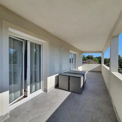 an empty balcony of a house with a table at appartement Oliviaaxelle in Venzolasca