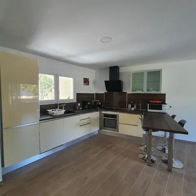 a large kitchen with a wooden table in it at appartement Oliviaaxelle in Venzolasca