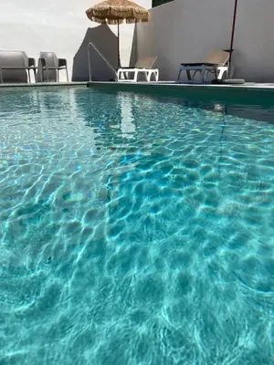 a large swimming pool with chairs and an umbrella at Résidence 