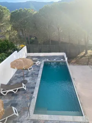 a swimming pool with a table and an umbrella at Résidence 