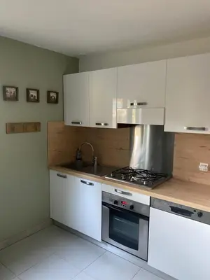 a kitchen with white cabinets and a stove top oven at Résidence 