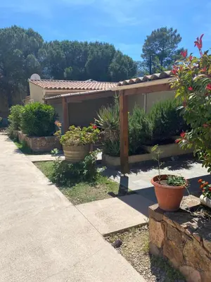 a garden with potted plants and a wooden pergola at Résidence 