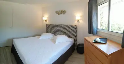 a bedroom with a bed and a dresser and a window at Duplex à 100 m de la plage in Grosseto-Prugna