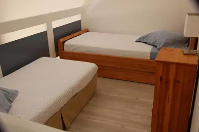 a small room with two beds and a table at Duplex à 100 m de la plage in Grosseto-Prugna
