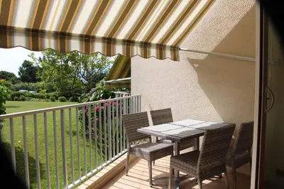a patio table and chairs on a balcony at Duplex à 100 m de la plage in Grosseto-Prugna