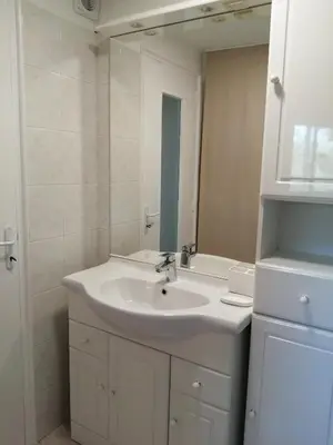 a white bathroom with a sink and a mirror at Duplex à 100 m de la plage in Grosseto-Prugna
