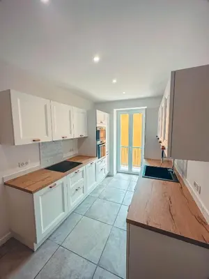 a kitchen with white cabinets and a wooden counter top at Liviamariasanta in Ajaccio