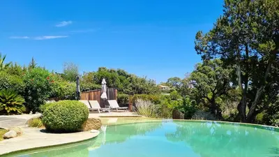 a swimming pool in a yard with a chair and trees at Villa Capicciola, 8 pers, piscine, 30 m plage in Cirendinu