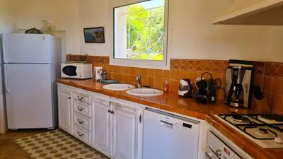 a kitchen with two sinks and a white refrigerator at Villa Capicciola, 8 pers, piscine, 30 m plage in Cirendinu