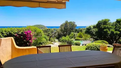 a table with chairs and a view of a garden at Villa Capicciola, 8 pers, piscine, 30 m plage in Cirendinu