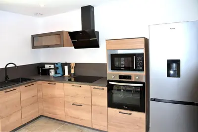 a kitchen with stainless steel appliances and wooden cabinets at Casa Solana - Piscine privée in Galeria