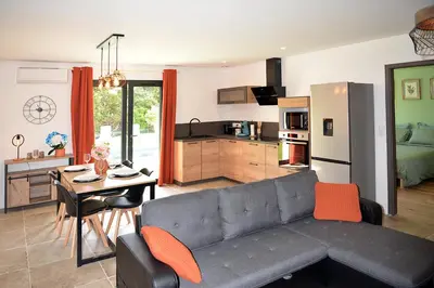 a living room with a couch and a table and a kitchen at Casa Solana - Piscine privée in Galeria