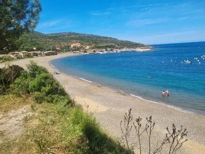 a beach with people swimming in the water at Casa Solana - Piscine privée in Galeria