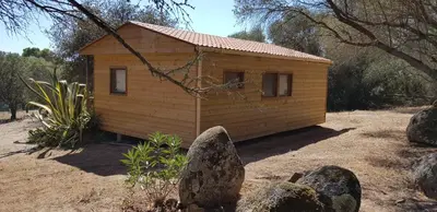 a small wooden house with rocks in front of it at Chalet Cosy - U Nestru in Olmeto