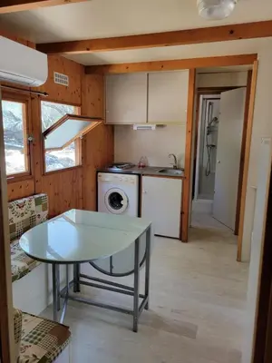a kitchen with a glass table and a stove at Chalet Cosy - U Nestru in Olmeto