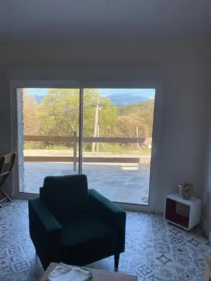 a living room with a chair and a large window at Villa in Piedigriggio