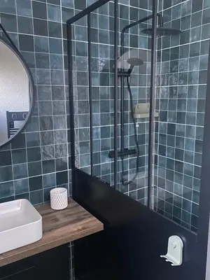a blue tiled bathroom with a sink and a shower at Villa in Piedigriggio