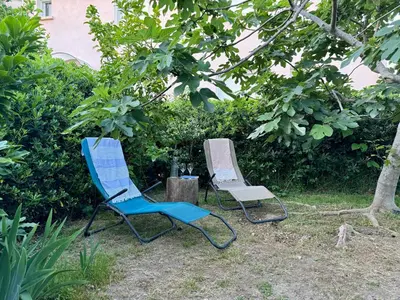 two blue and white chairs sitting under a tree at Evasion de rêve à Casa Nina in Borgo