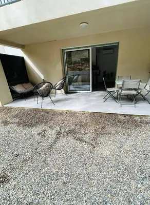 a patio with two chairs and a table and a couch at Appartement T2 Corte in Corte