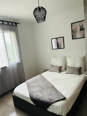 a bedroom with a large white bed with two pillows at Appartement T2 Corte in Corte