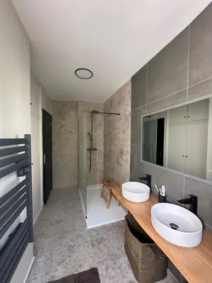 a bathroom with two sinks and a shower at Appartement de standing, vue mer, 3 chambres in Ajaccio