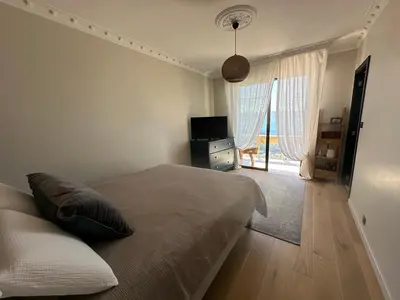 a bedroom with a bed and a television and a window at Appartement de standing, vue mer, 3 chambres in Ajaccio