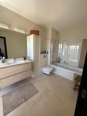 a bathroom with a sink and a toilet and a tub at Appartement de standing, vue mer, 3 chambres in Ajaccio