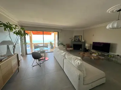 a living room with a white couch and a television at Appartement de standing, vue mer, 3 chambres in Ajaccio