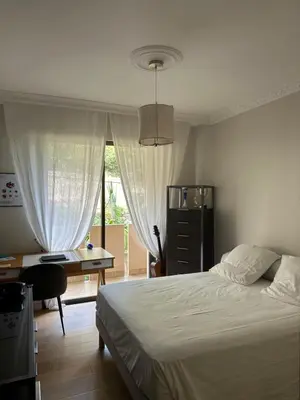 a bedroom with a bed and a desk and a window at Appartement de standing, vue mer, 3 chambres in Ajaccio