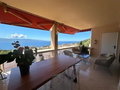 a dining room with a table and a view of the ocean at Appartement de standing, vue mer, 3 chambres in Ajaccio