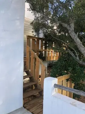 a wooden staircase leading to a house with a tree at Villa Taru Pinarello in Mangialla