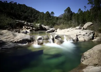 a river with rocks and waterfalls at Villa Taru Pinarello in Mangialla