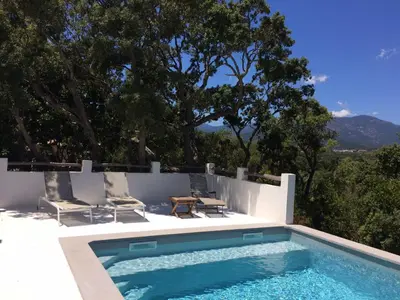 a swimming pool on the side of a house at Villa Taru Pinarello in Mangialla