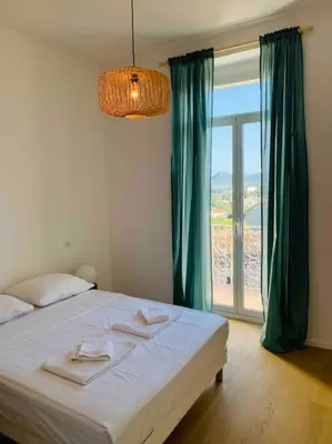 a bedroom with a bed and a large window at Grand logement standing centre ville Porto-Vecchio in Porto-Vecchio
