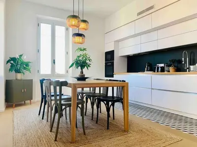 a kitchen with a wooden table and chairs at Grand logement standing centre ville Porto-Vecchio in Porto-Vecchio