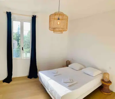 a bedroom with a white bed and a window at Grand logement standing centre ville Porto-Vecchio in Porto-Vecchio
