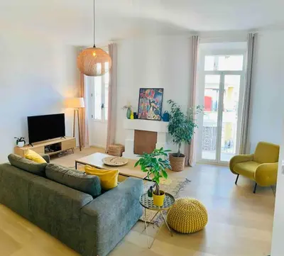 a living room with a couch and a tv at Grand logement standing centre ville Porto-Vecchio in Porto-Vecchio